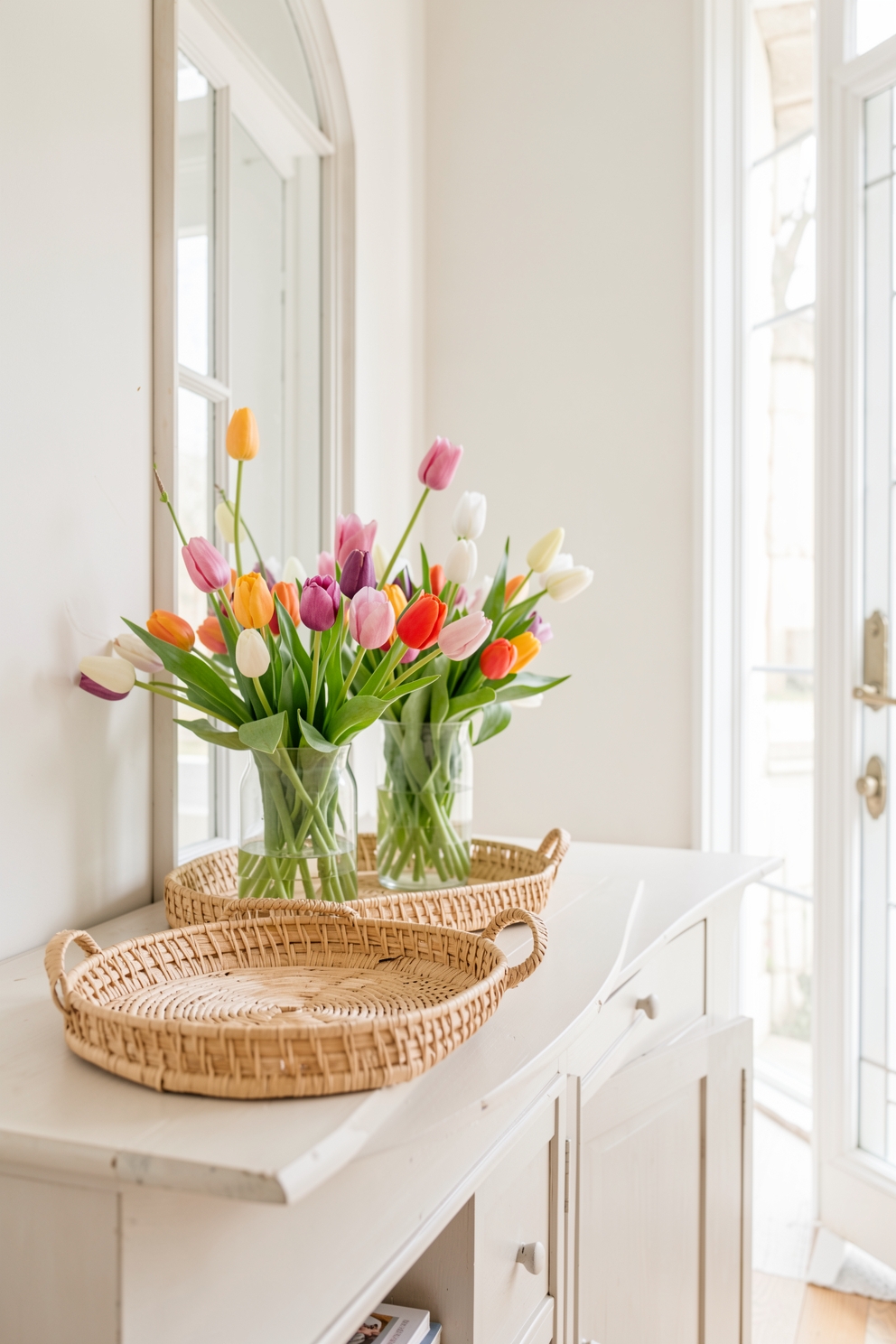 Bright spring entryway with fresh tulips on a console table